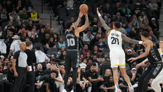 Dec 26, 2023; San Antonio, Texas, USA; San Antonio Spurs forward Julian Champagnie (30) shoots over Utah Jazz forward John Collins (20) in the first half at the Frost Bank Center.